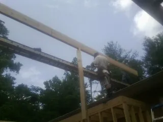 Carpenter setting a ridge beam over a new addition frame — Ice Dam Removal by Roofing Brothers in Mohawk