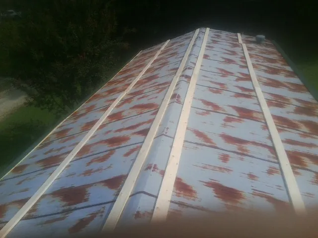 Rusted metal roof panels with new wood purlins before replacement — Storm Damage Roof Repair in Mohawk by Roofing Brothers