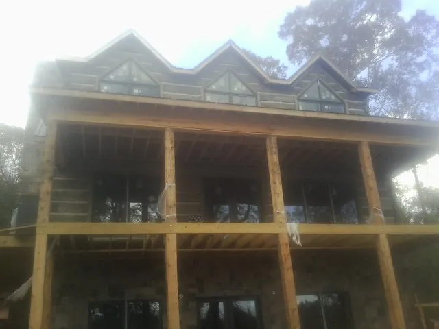 Dormers and porch framing on a large log home under construction — Roof Coating work by our crew in Mohawk