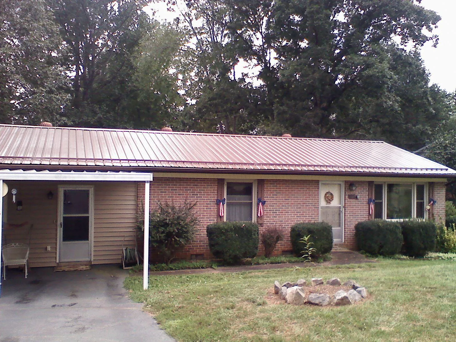 Bronze metal roof and carport on a brick ranch home — Roof Repair work by our crew in Mohawk